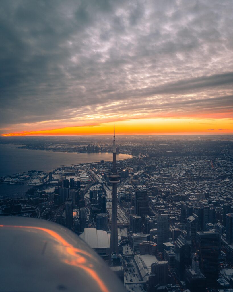 Stunning aerial view of Toronto skyline featuring CN Tower at sunset, vibrant cityscape perfect for travel and urban themes.