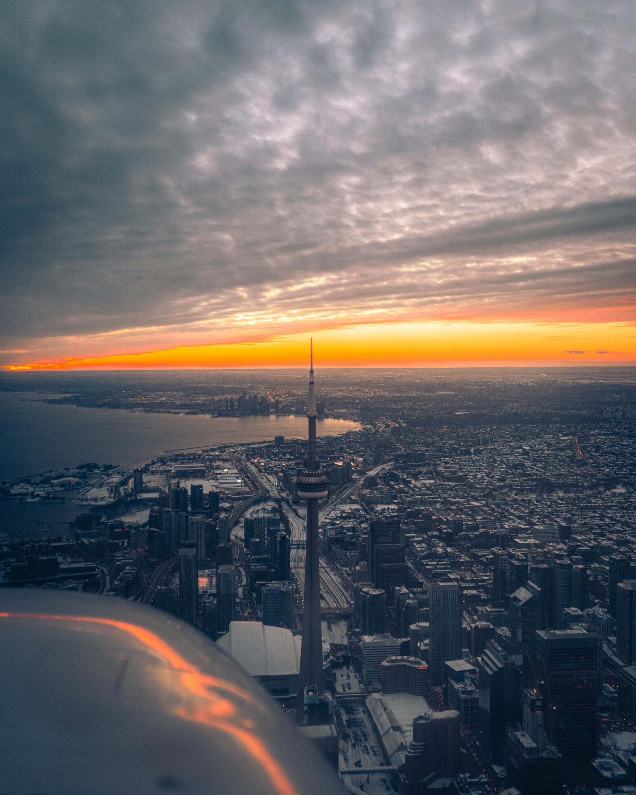 Stunning aerial view of Toronto skyline featuring CN Tower at sunset, vibrant cityscape perfect for travel and urban themes.
